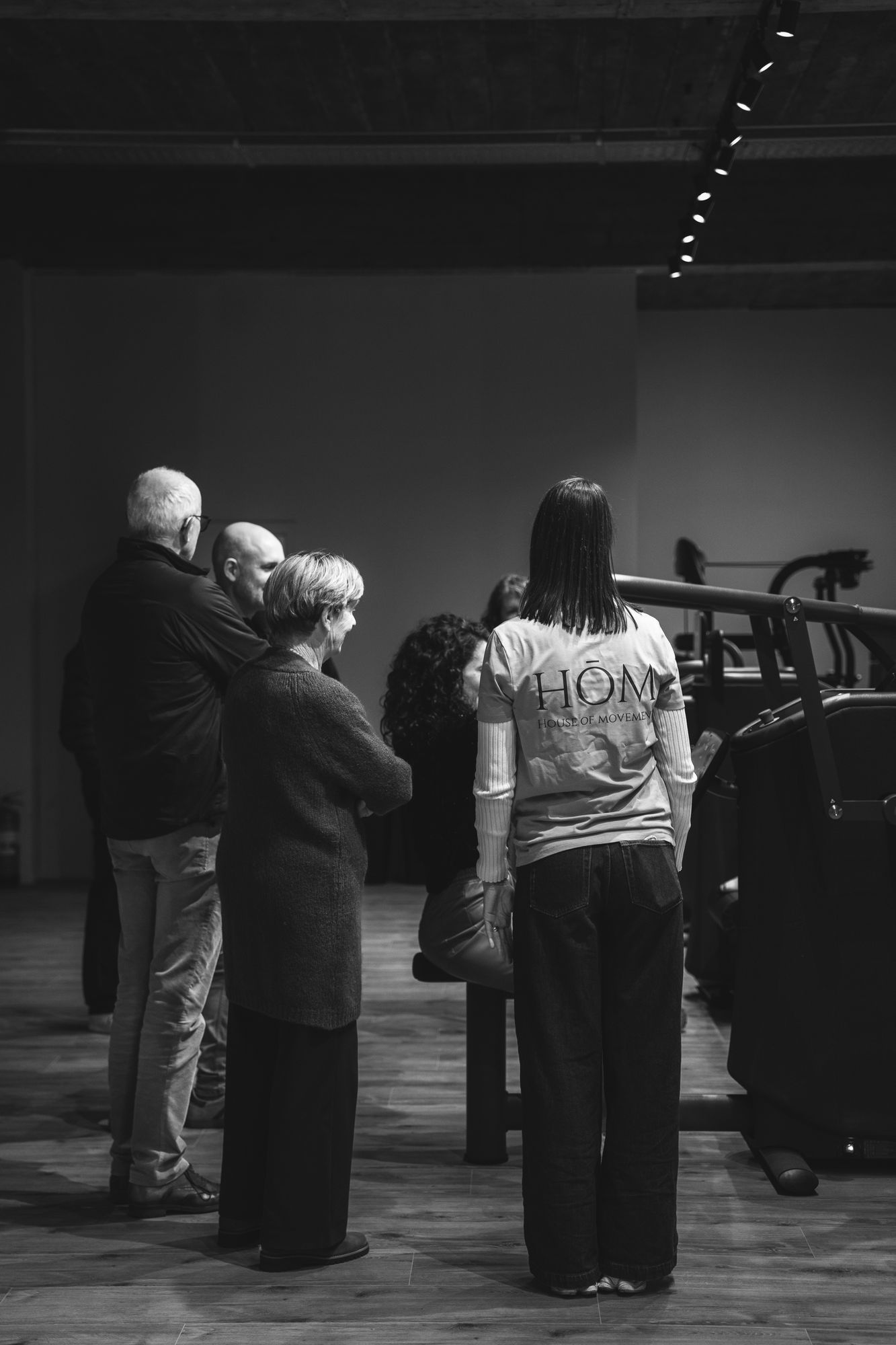 Leden en coaches in gesprek in de zaal van HŌM