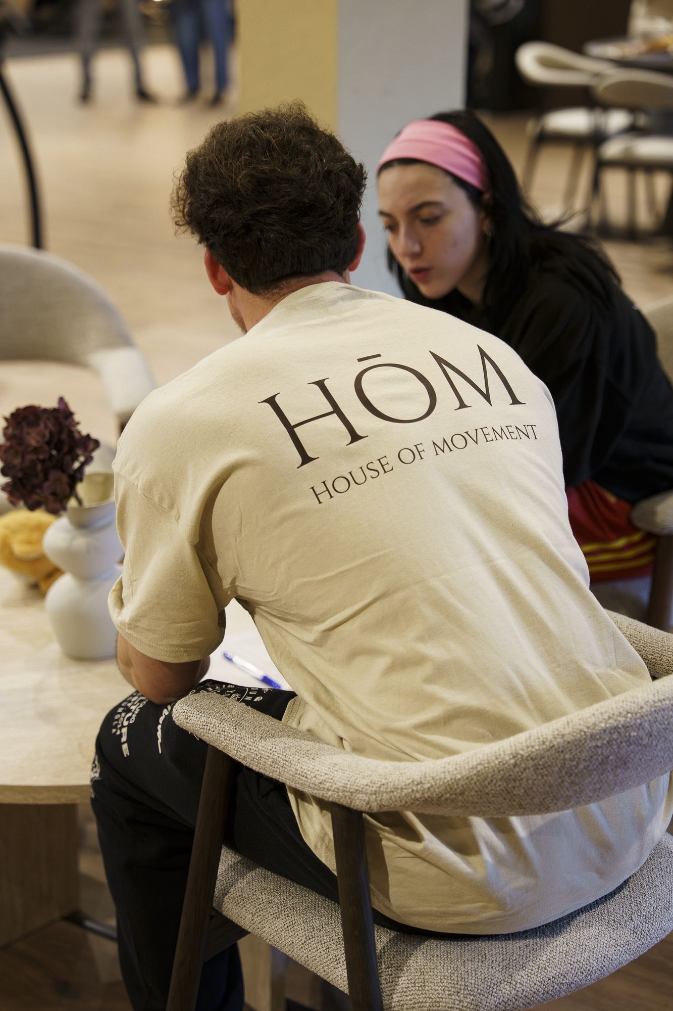 Lid in een HŌM-shirt in de lounge